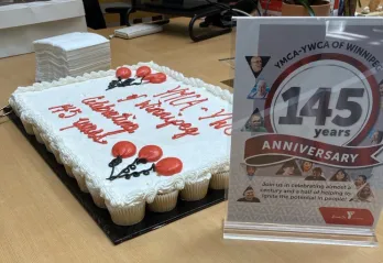 Image of 145 year anniversary sign in front of cupcakes