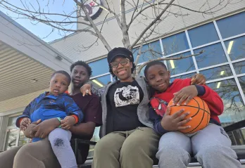 Olu and family sitting outside the South Y