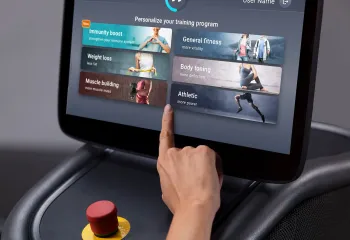 Hand tapping touchscreen on EGYM equipment