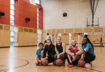 diverse group of people in a gymnasium posing in front of camera