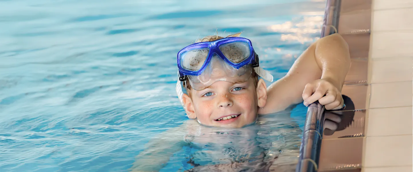 Boy with Goggles on Head in the Pool