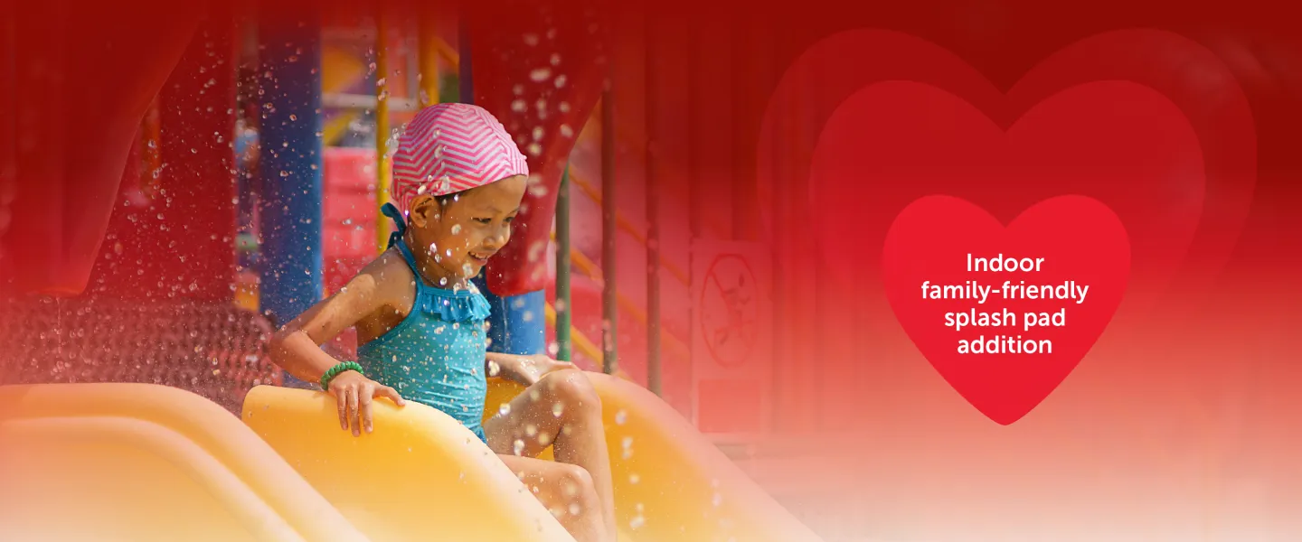 Picture of young girl on slide at splash pad with the words "indoor, family-friendly splash pad addition"