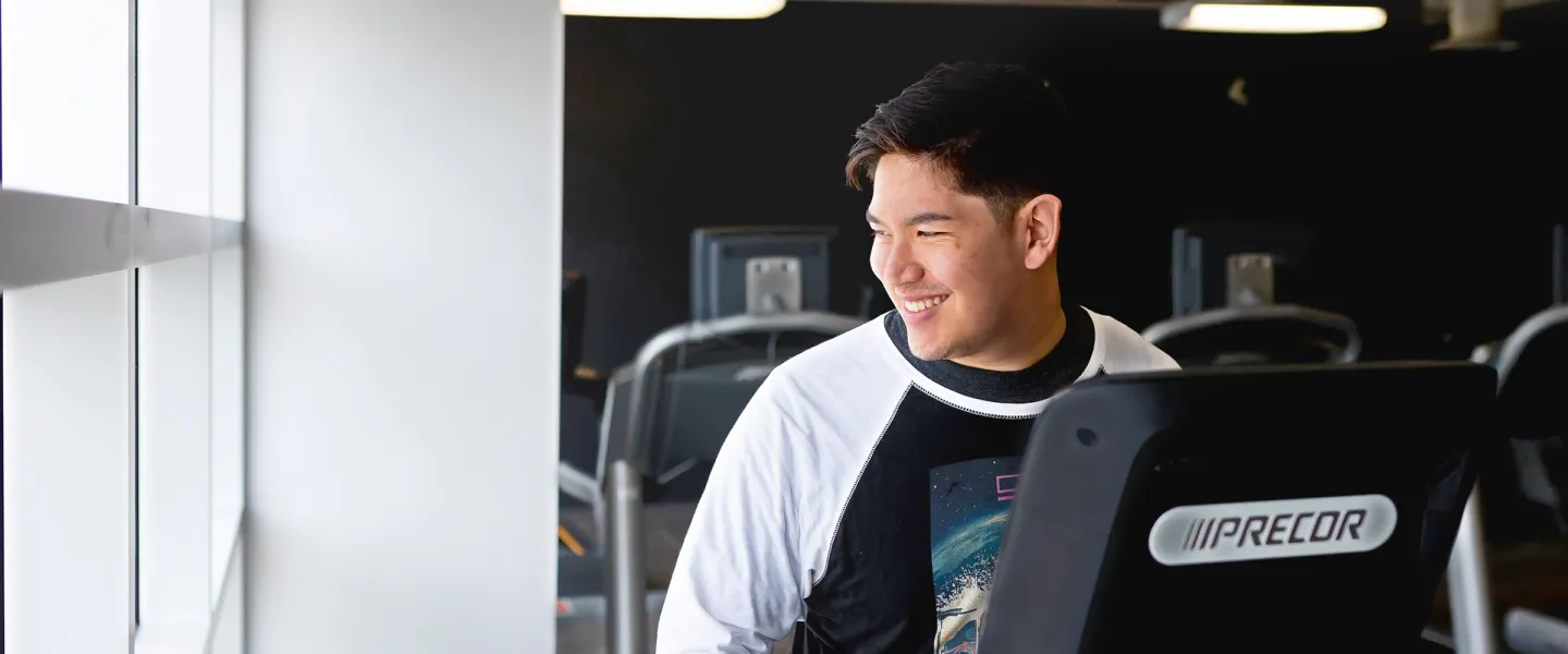 Young Smiling Man on Stepper Near Window