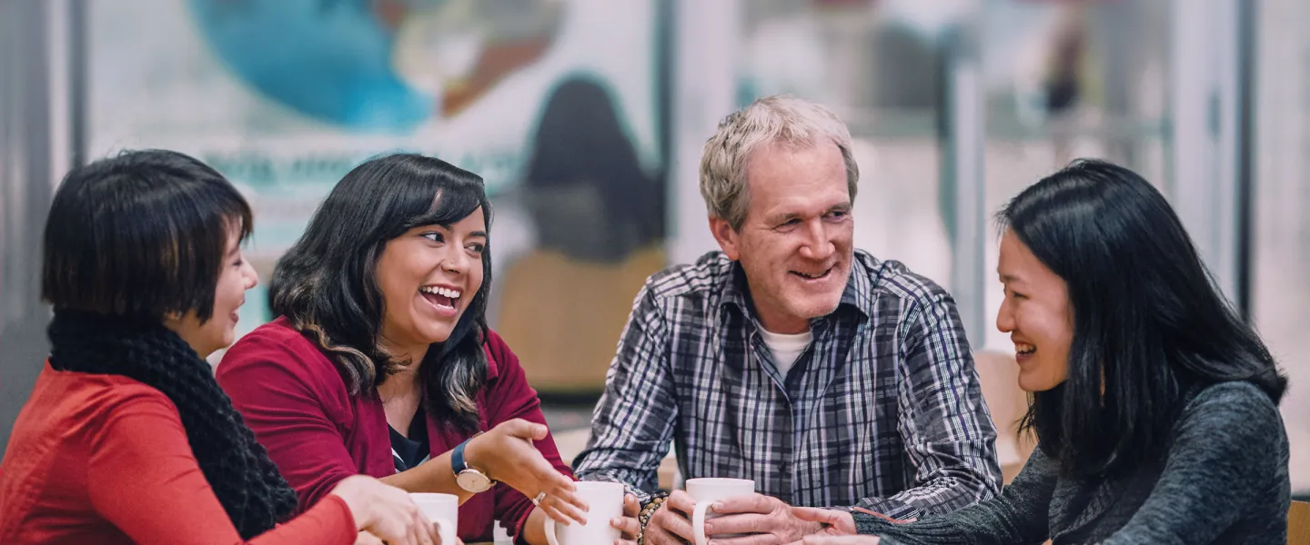 Group of people sitting together at a table and talking