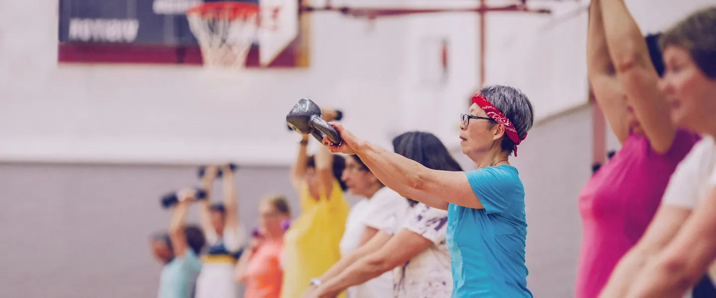 Group of women in an exercise class using weights