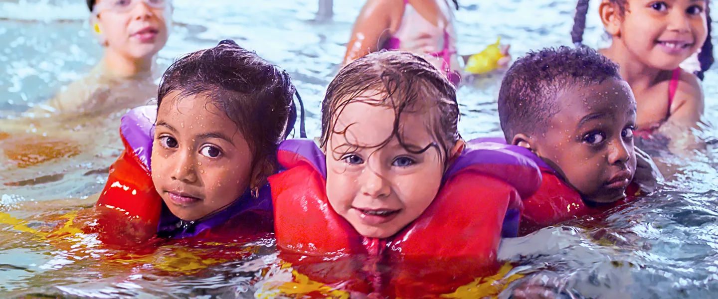 Group of children wearing lifejackets in the pool