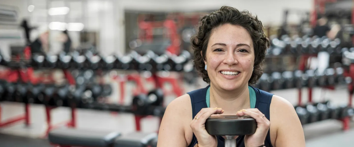 Woman goblet squatting a weight in fitness centre