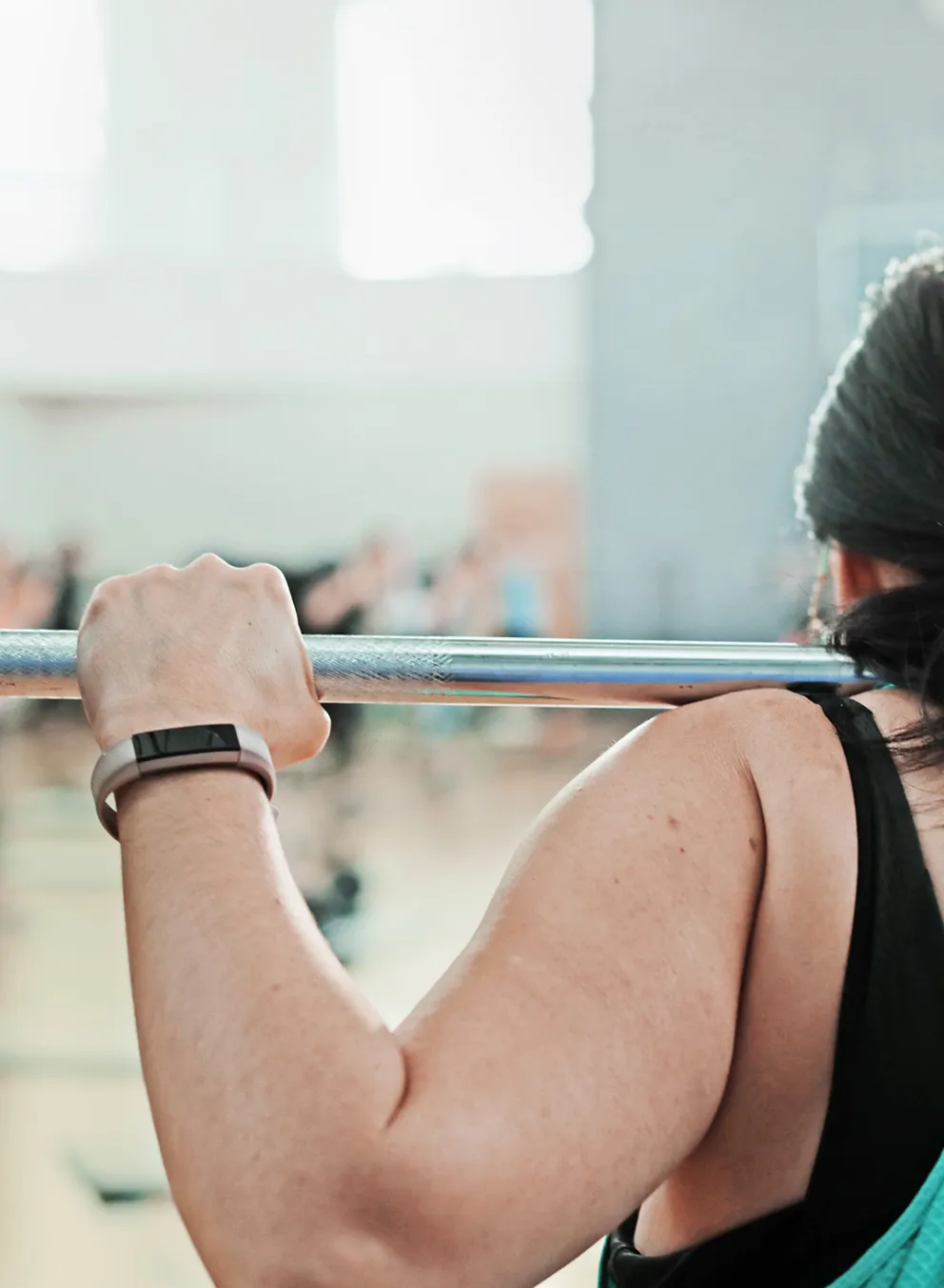 Back View of Woman Lifting Weights in a Class