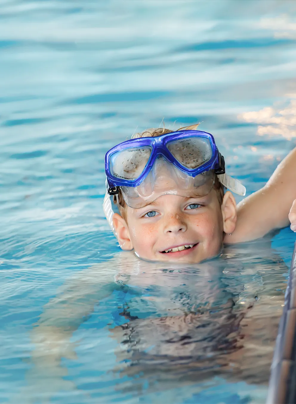 Boy with Goggles on Head in the Pool