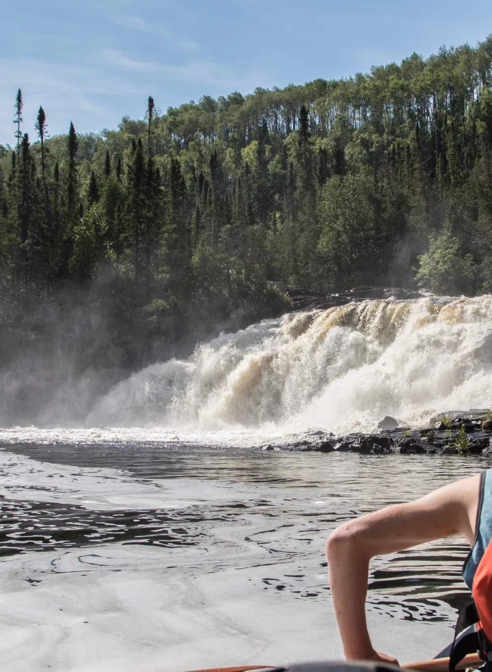 canoeist looking at waterfall scenery