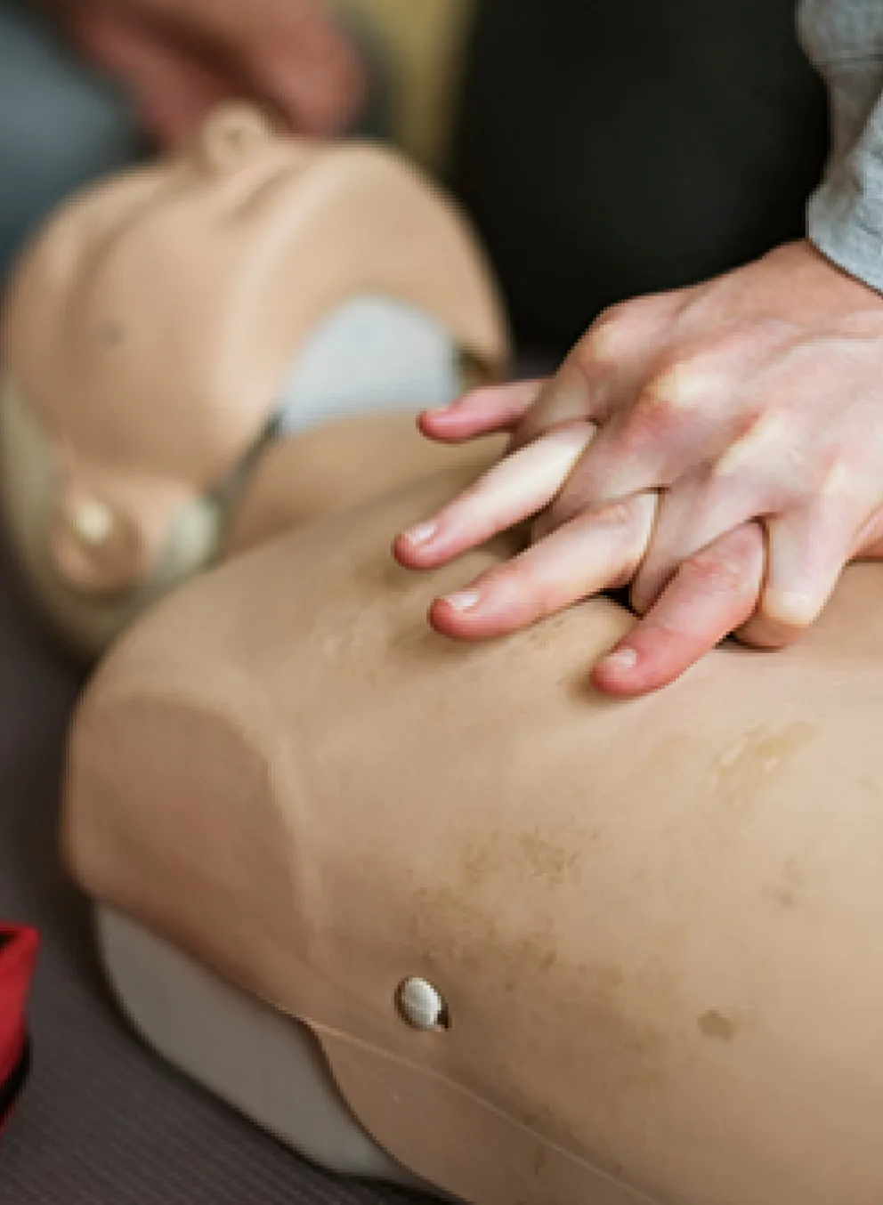 [Image] close-up of person performing chest compressions on CPR dummy