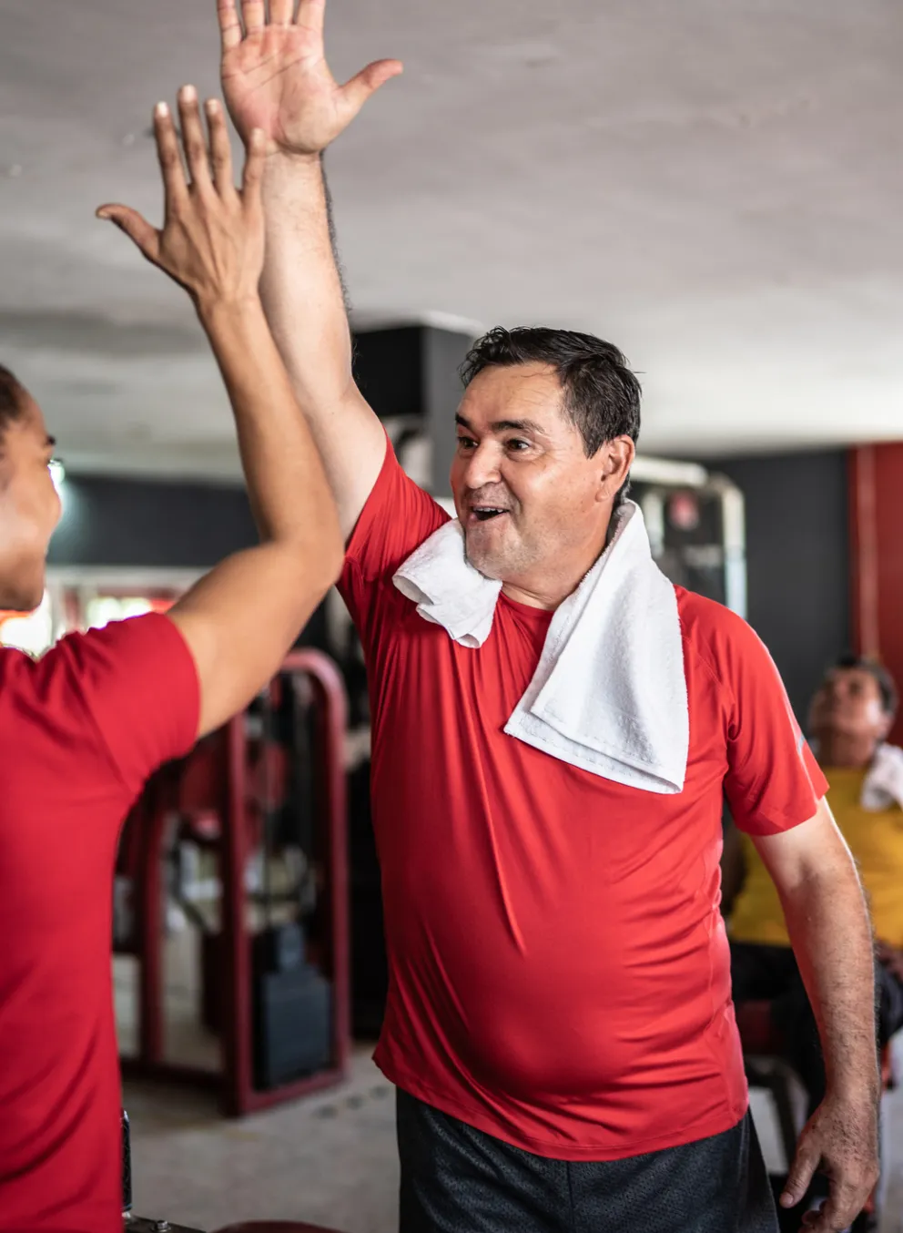 [Image] Man in fitness centre giving coach a high five