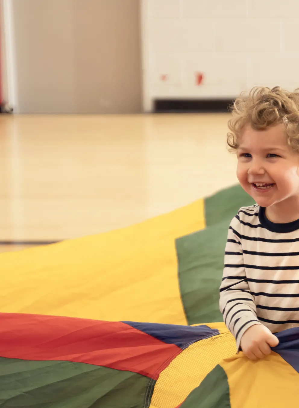 Preschool kid playing with parachute