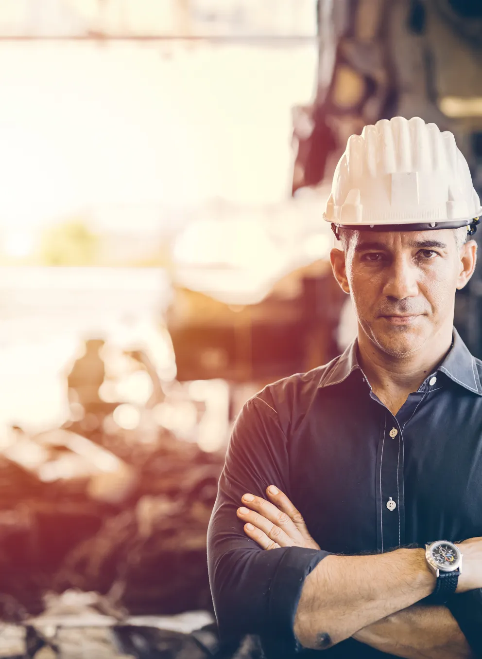 [Image} man with hard hat standing in front of construction site