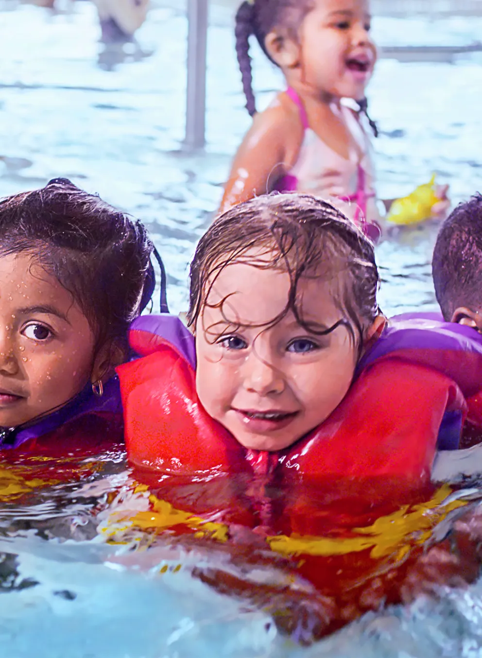 Group of children wearing lifejackets in the pool