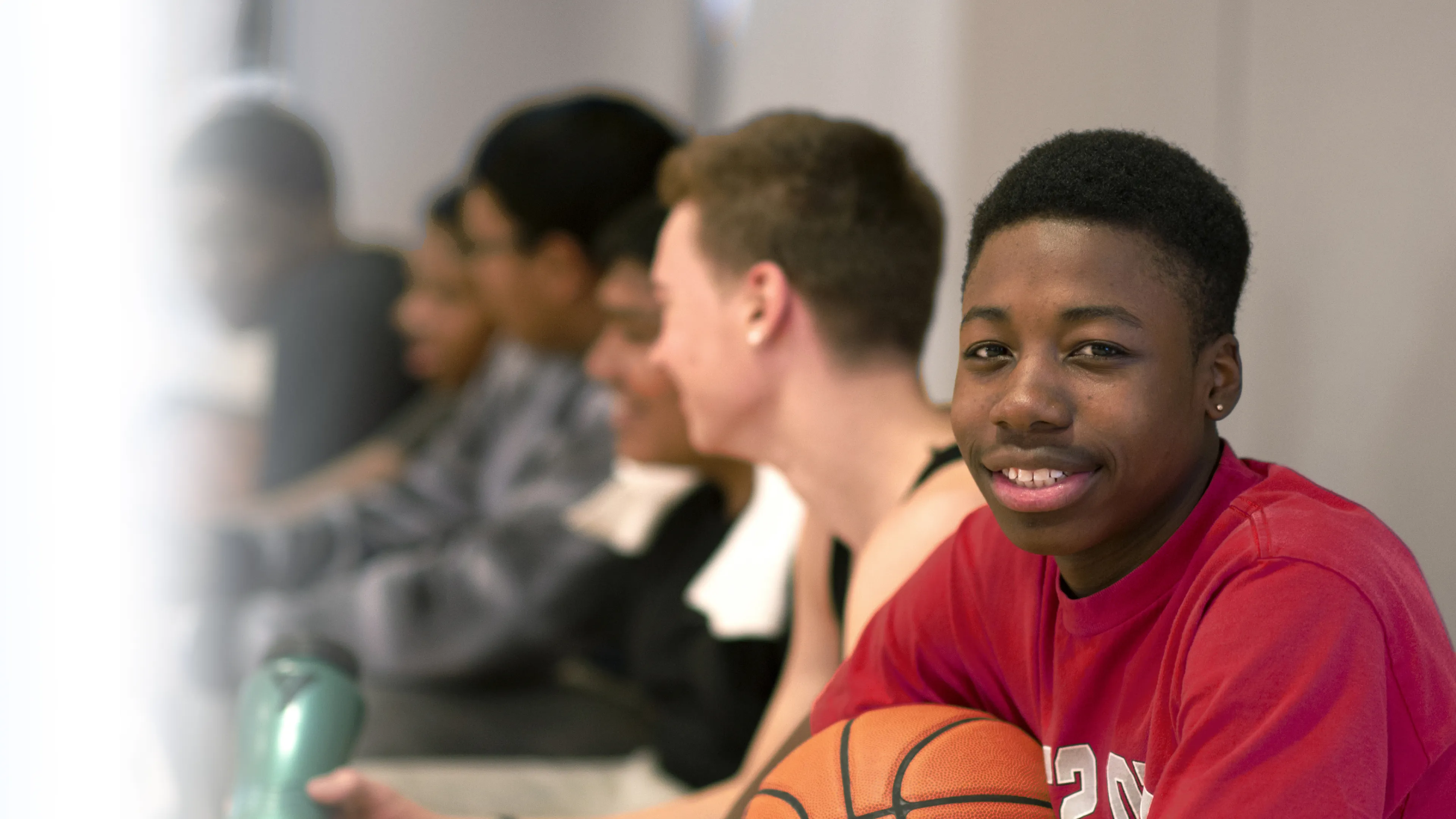 Boys with basketball siting on bench