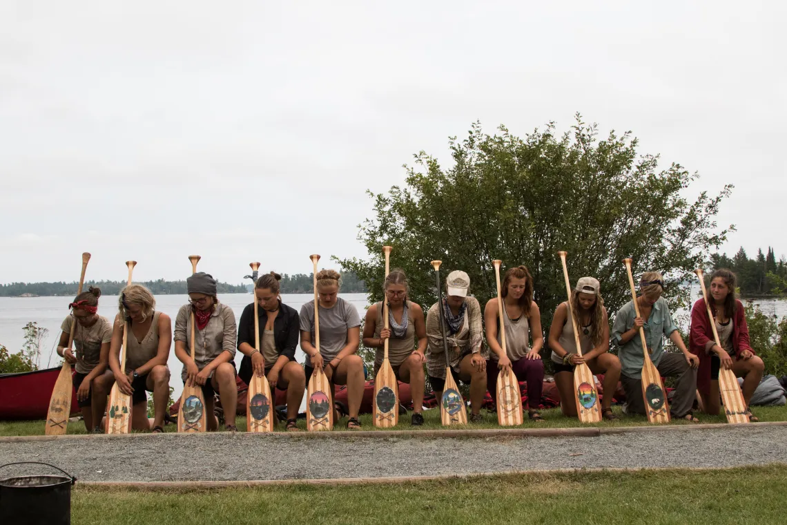 Girls Kneeling to Show Art on Paddles