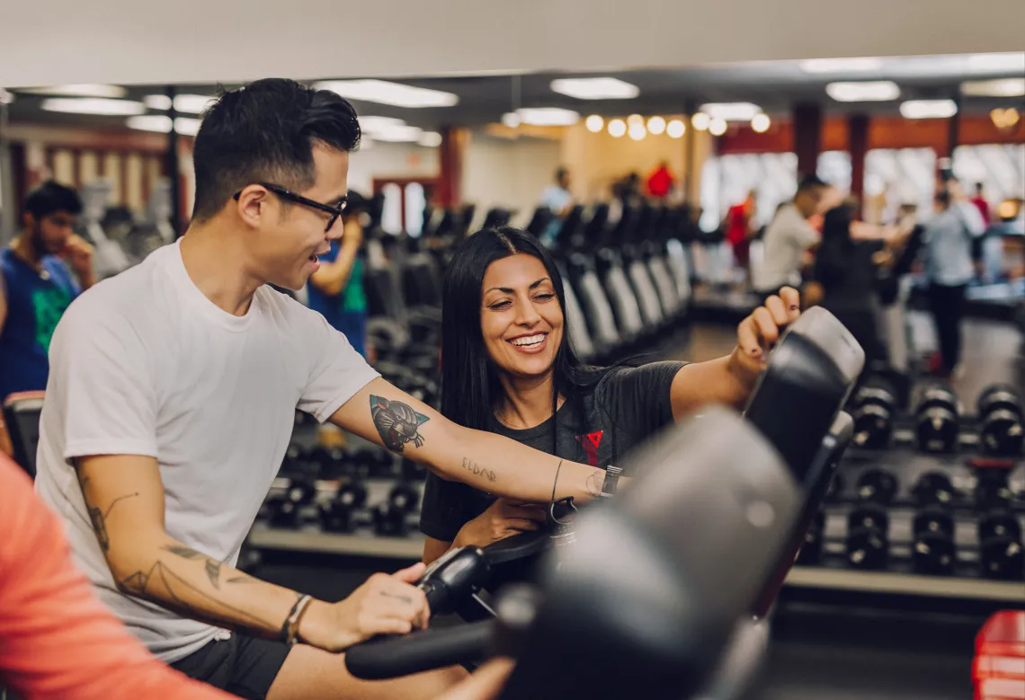 Trainer Helping Client on Bike