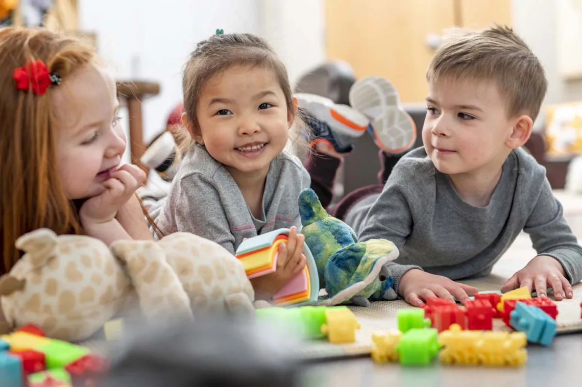 Three Preschool Kids in Child Care Playing with Toys