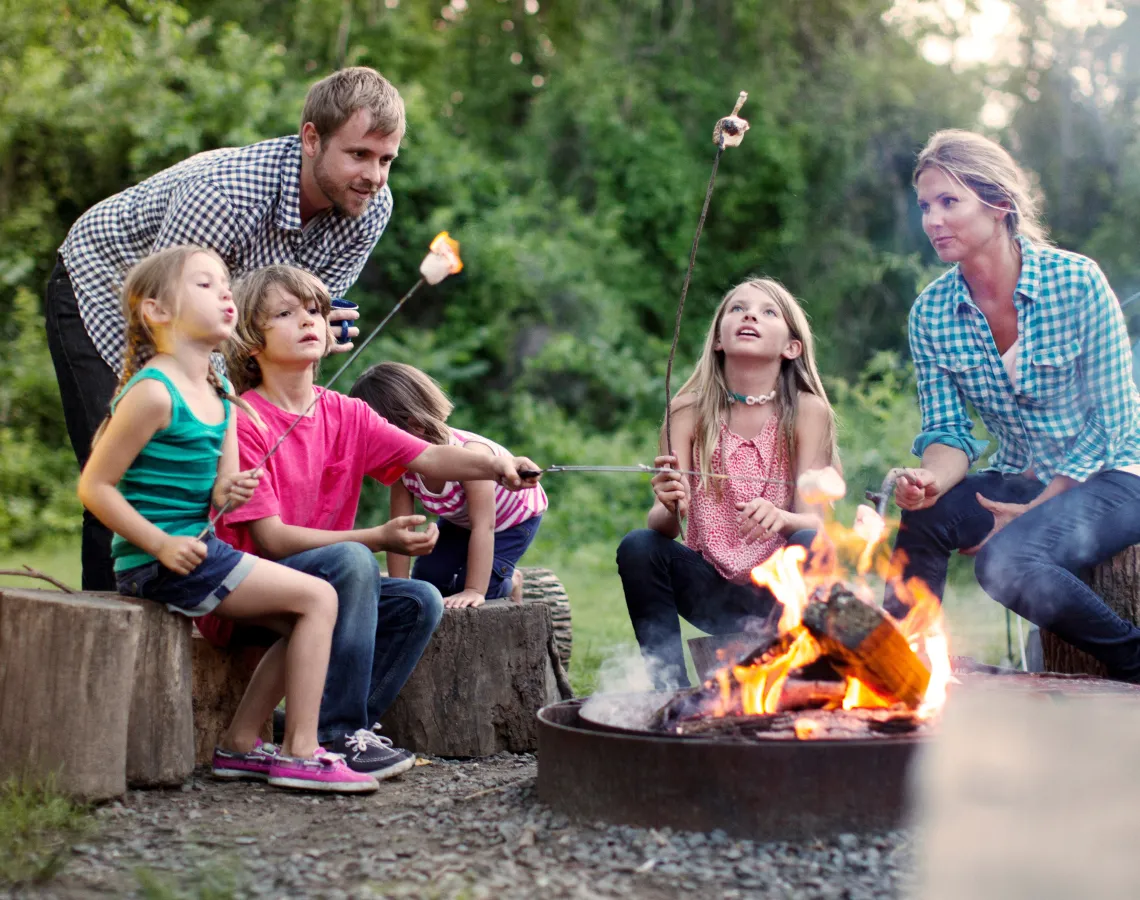 family around a campfire roasting marshmallows