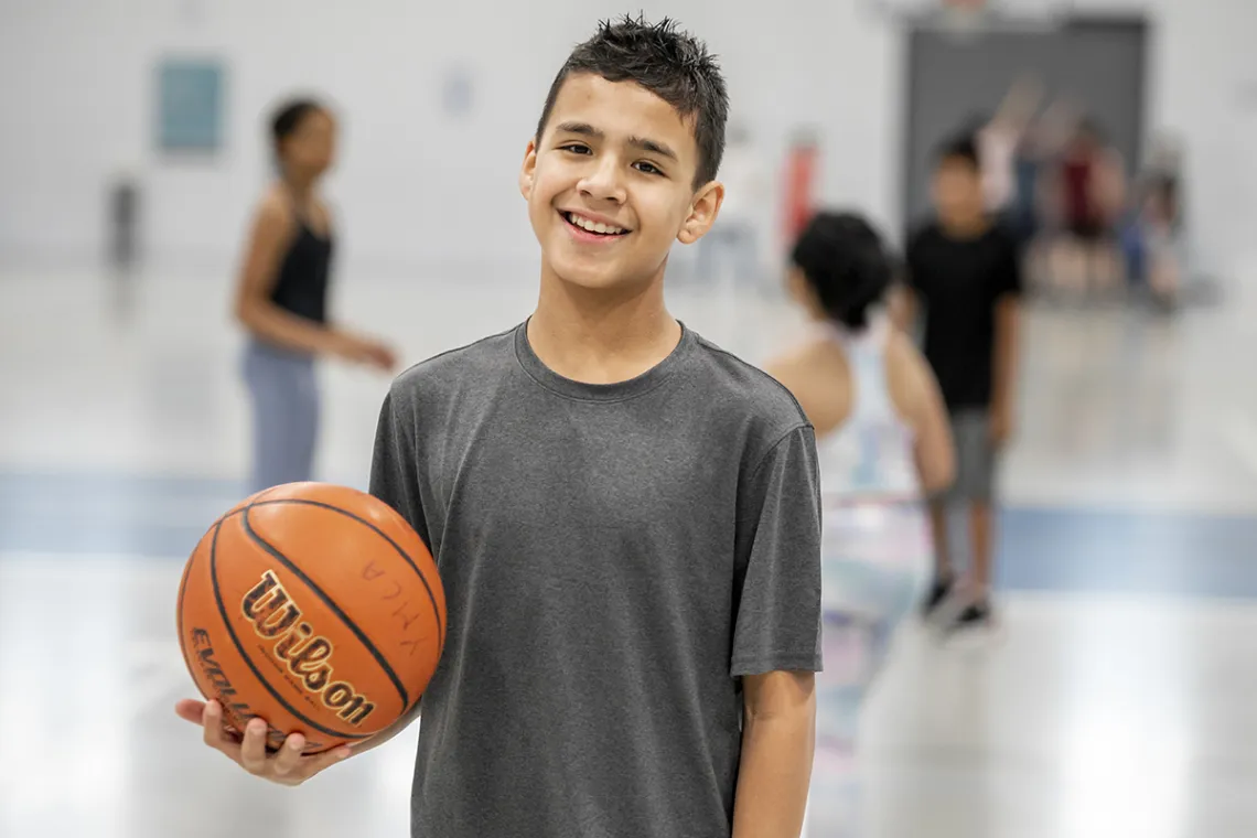 Image of youth holding a basketball in a gym