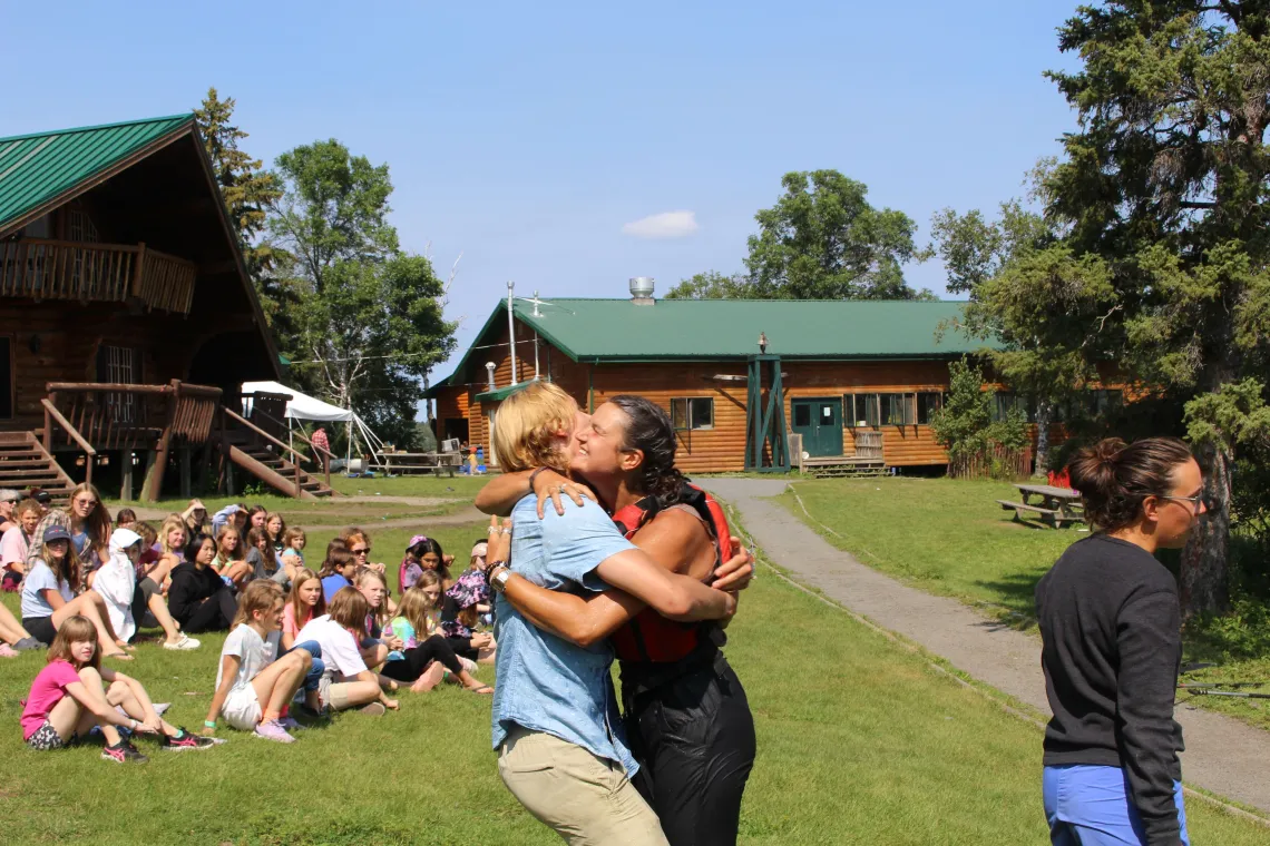 a camper embraces a woman during the Return Ceremony