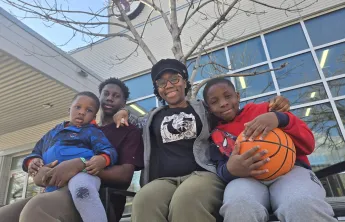Olu and family sitting outside the South Y