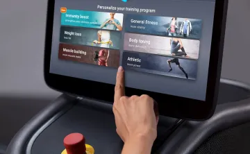 Hand tapping touchscreen on EGYM equipment