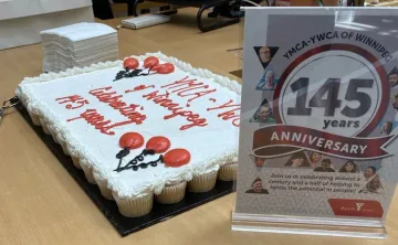 Image of 145 year anniversary sign in front of cupcakes