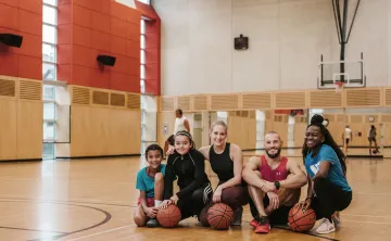 diverse group of people in a gymnasium posing in front of camera