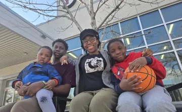 Olu and family sitting outside the South Y